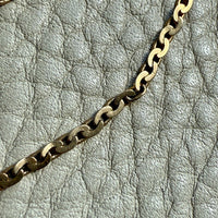 Gold chain on a textured gray surface