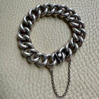 Silver chain bracelet on a textured beige surface