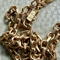 vintage 18k yellow gold biker link chain necklace on a textured light gray surface