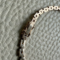 14k Gold vintage chain necklace on a textured gray background