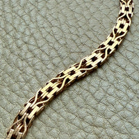 Gold bracelet on a textured light gray surface