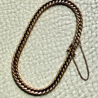18k vintage Gold curb chain bracelet on a textured light gray surface