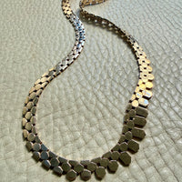 Necklace with hexagonal beads on a textured surface