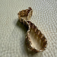 Gold bracelet on a textured light gray surface