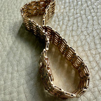 Gold bracelet on a textured light gray surface
