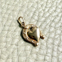 Gold heart-shaped pendant on a textured light green background