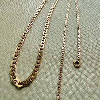 vintage 18k Gold virola link necklace on a textured light beige surface penelopepenelope.com