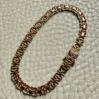 18k Gold chain bracelet on a textured light gray surface