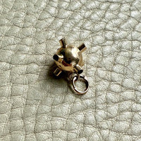 Gold charm on a textured surface