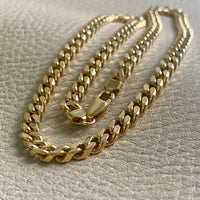A 20-inch long, 18k gold vintage Italian curb link necklace with a secure clasp, laid out on a textured surface.