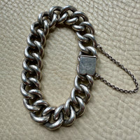 Silver chain bracelet on a textured beige surface