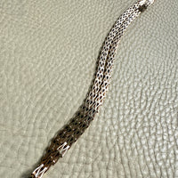 gold necklace with a pattern on a textured surface