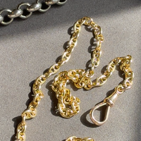 Gold and silver chain necklaces on a gray surface