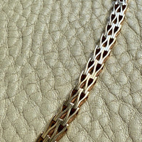 Gold chain on a textured beige background