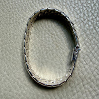 Silver bracelet on a textured beige surface