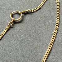 Gold chain necklace on a gray background