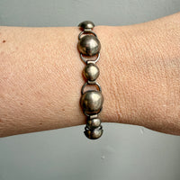 A silver bubble link bracelet displayed on a person's wrist, featuring a series of round and bubble-shaped links.