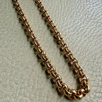 Gold chain on a light gray textured surface