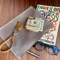 Simple leather zipper pouch to keep you organized. Bovine suede. Measures 10” x 7” Metal zip with donut pull. Attach a wrist strap to zipper tab to make this into a clutch.