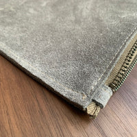 Simple leather zipper pouch to keep you organized. Bovine suede. Measures 10” x 7” Metal zip with donut pull. Attach a wrist strap to zipper tab to make this into a clutch.