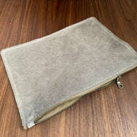 Simple leather zipper pouch to keep you organized. Bovine suede. Measures 10” x 7” Metal zip with donut pull. Attach a wrist strap to zipper tab to make this into a clutch.