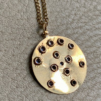 backside of 18k gold handmade medallion. Personal etching is visible