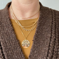 a woman wearing a collection of 18k gold vintage swedish necklaces