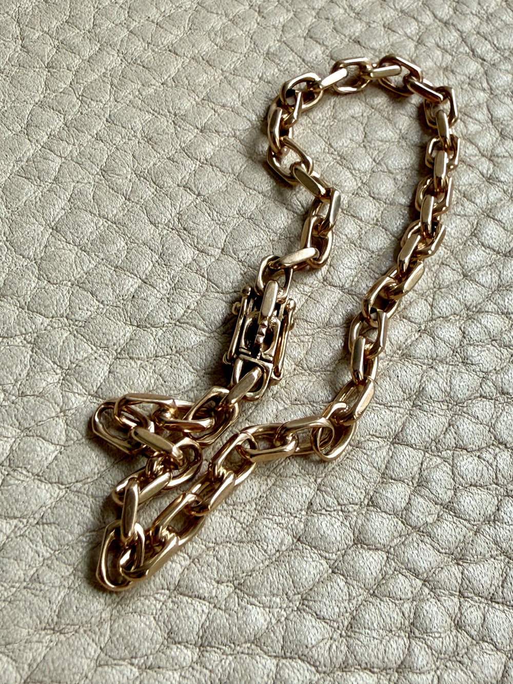 14k Gold vintage biker chain bracelet  on a textured light gray background