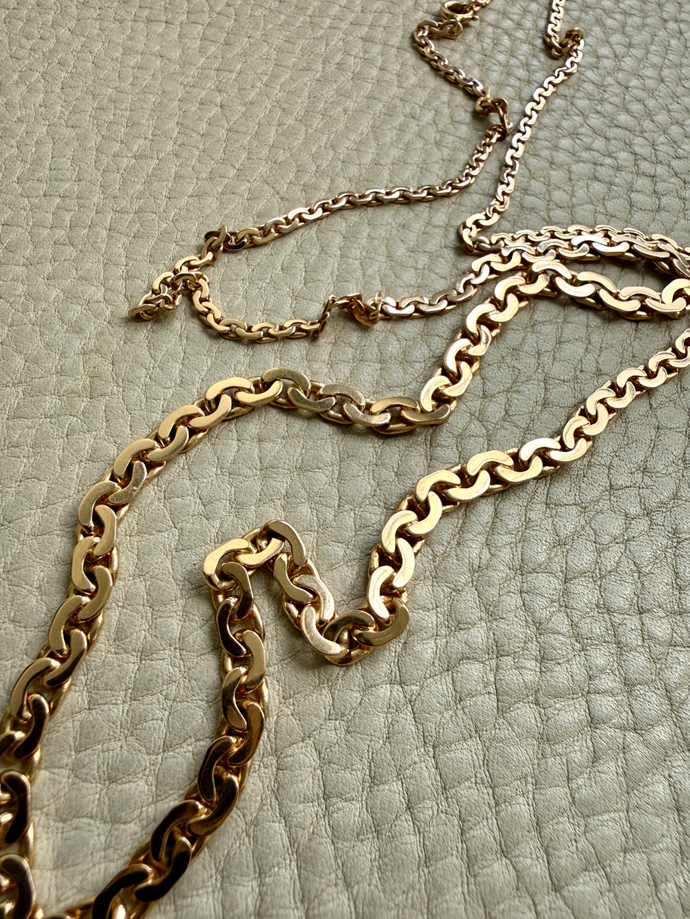 vintage 18k Gold virola link necklace on a textured light beige surface penelopepenelope.com