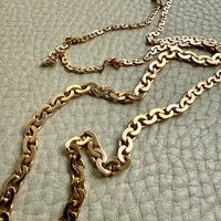 vintage 18k Gold virola link necklace on a textured light beige surface penelopepenelope.com