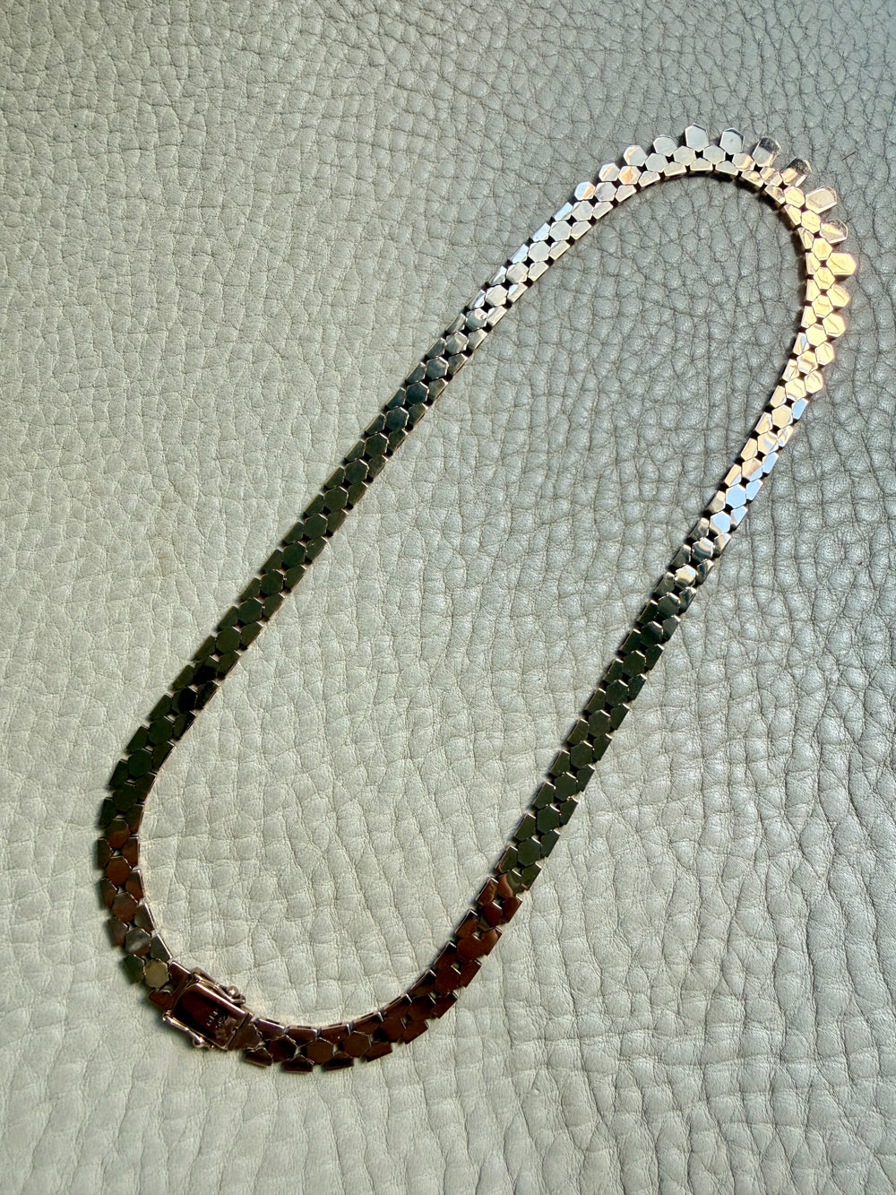 vintage 14k gold chain necklace on with hexagonal links on a textured surface