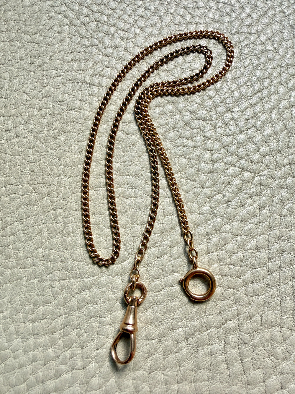 18k gold antique watch chain with clasp on a textured light gray background penelopepenelope.com