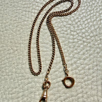18k gold antique watch chain with clasp on a textured light gray background penelopepenelope.com