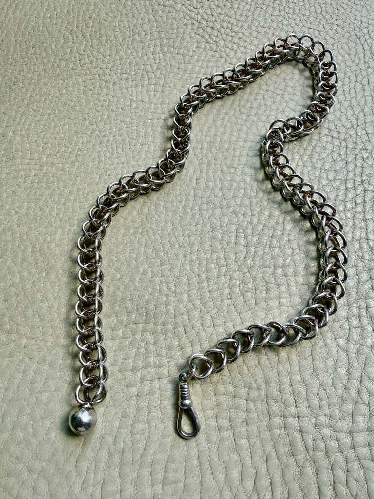Silver chain with a clasp on a textured gray background