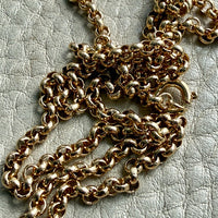 18k gold vintage rolo chain necklace on a textured light gray surface
