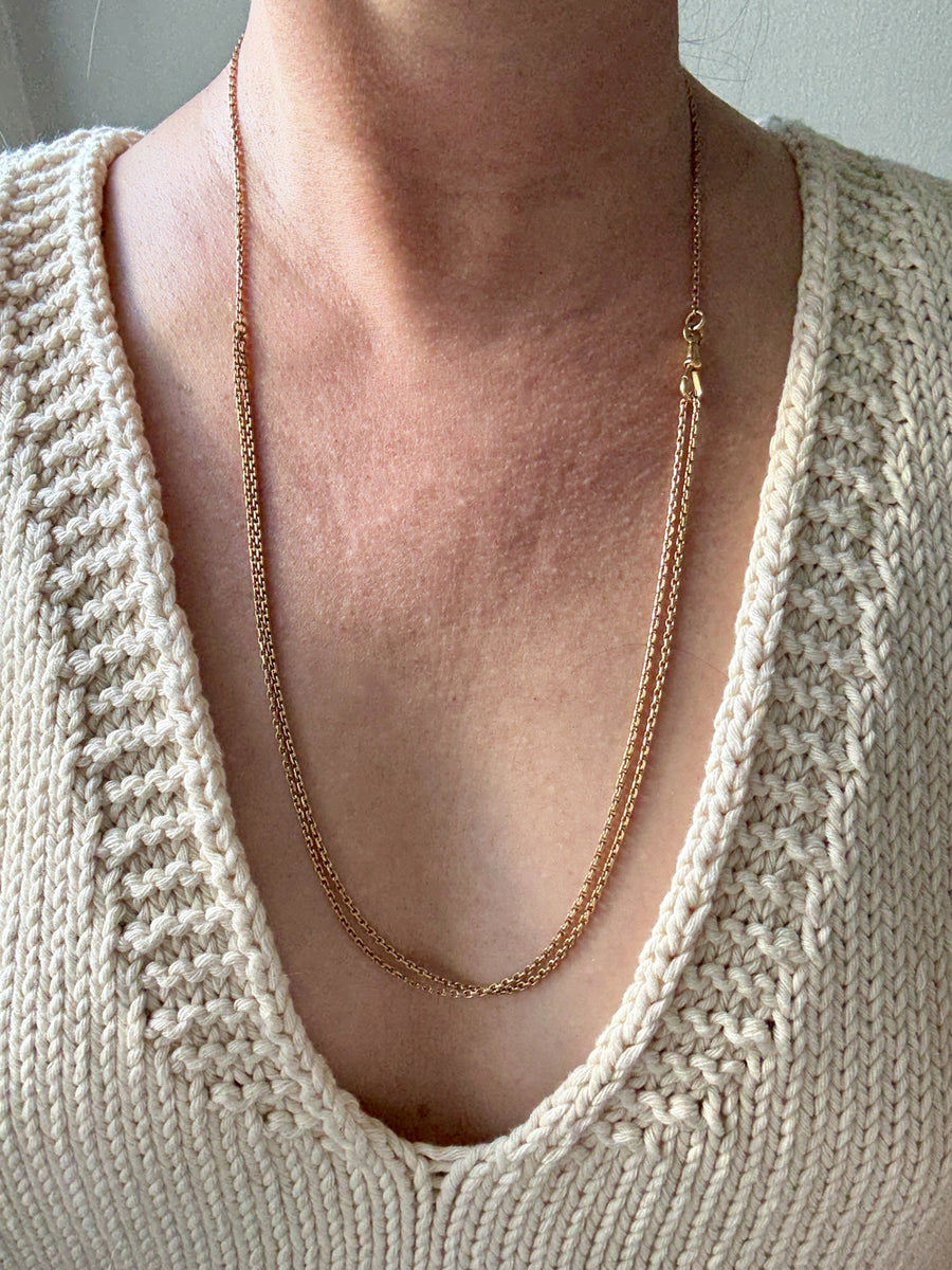 antique 18k gold Necklace worn by a person wearing a beige knit sweater