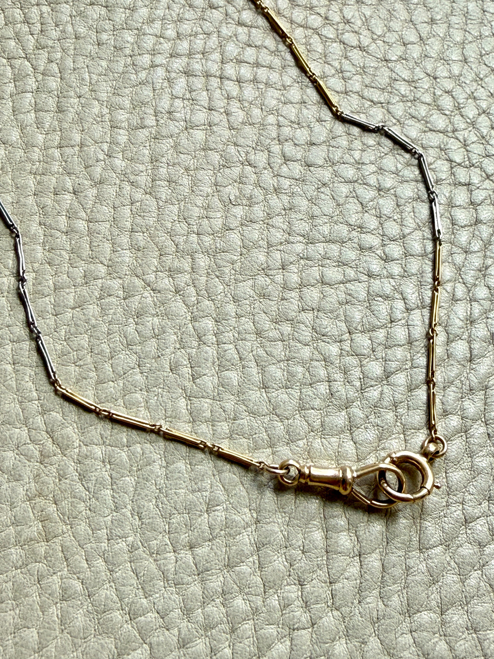Gold bracelet on a textured light gray surface