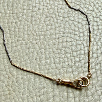 Gold bracelet on a textured light gray surface