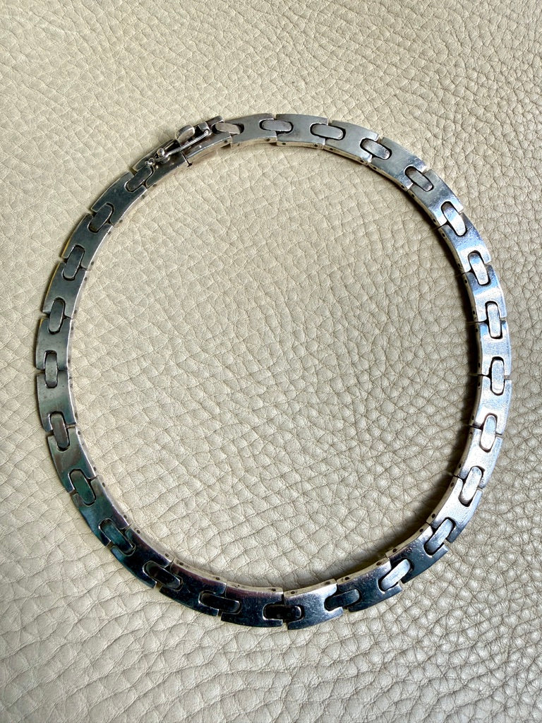 Silver bracelet on a textured beige surface