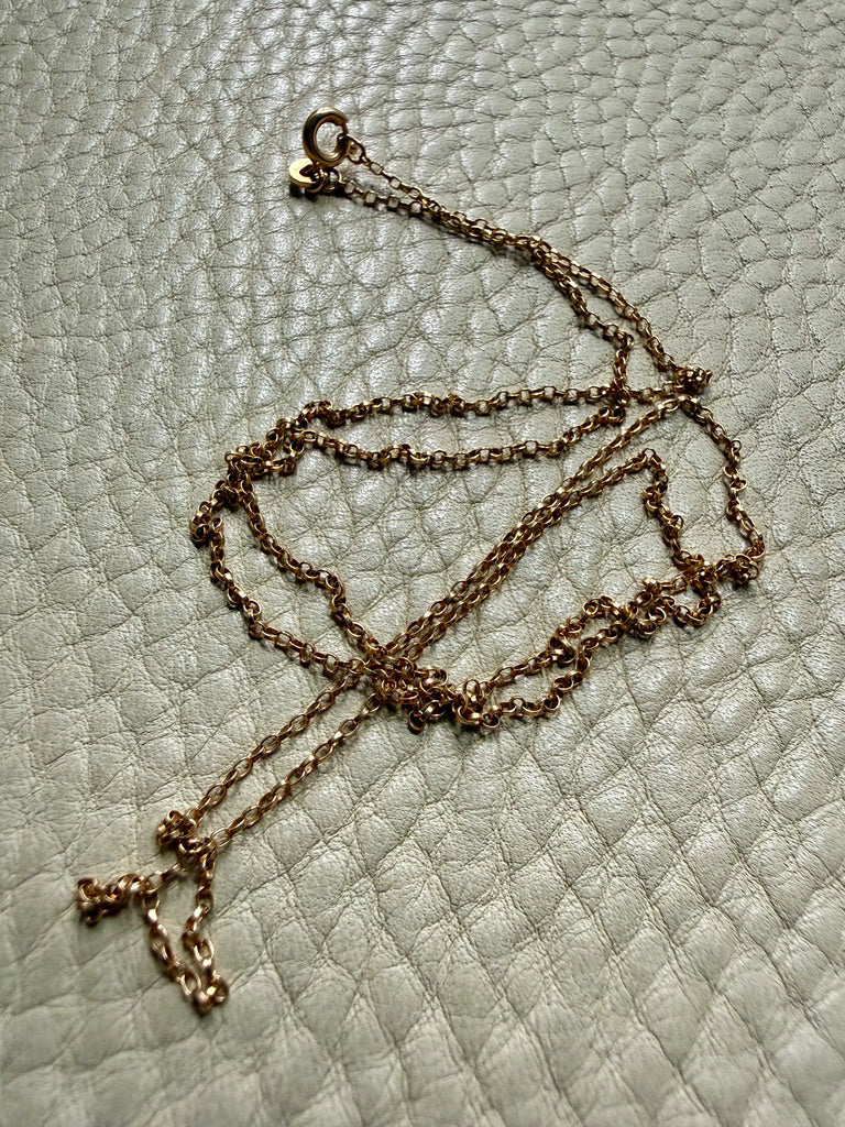 vintage 18k gold chain necklace on a textured light gray surface