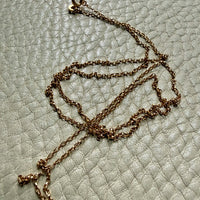 vintage 18k gold chain necklace on a textured light gray surface