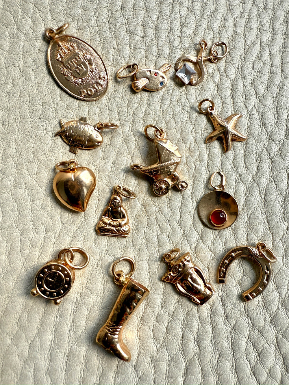 Collection of various gold charms on a textured surface