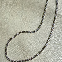 vintage 14k white gold chain  necklace on a textured beige surface