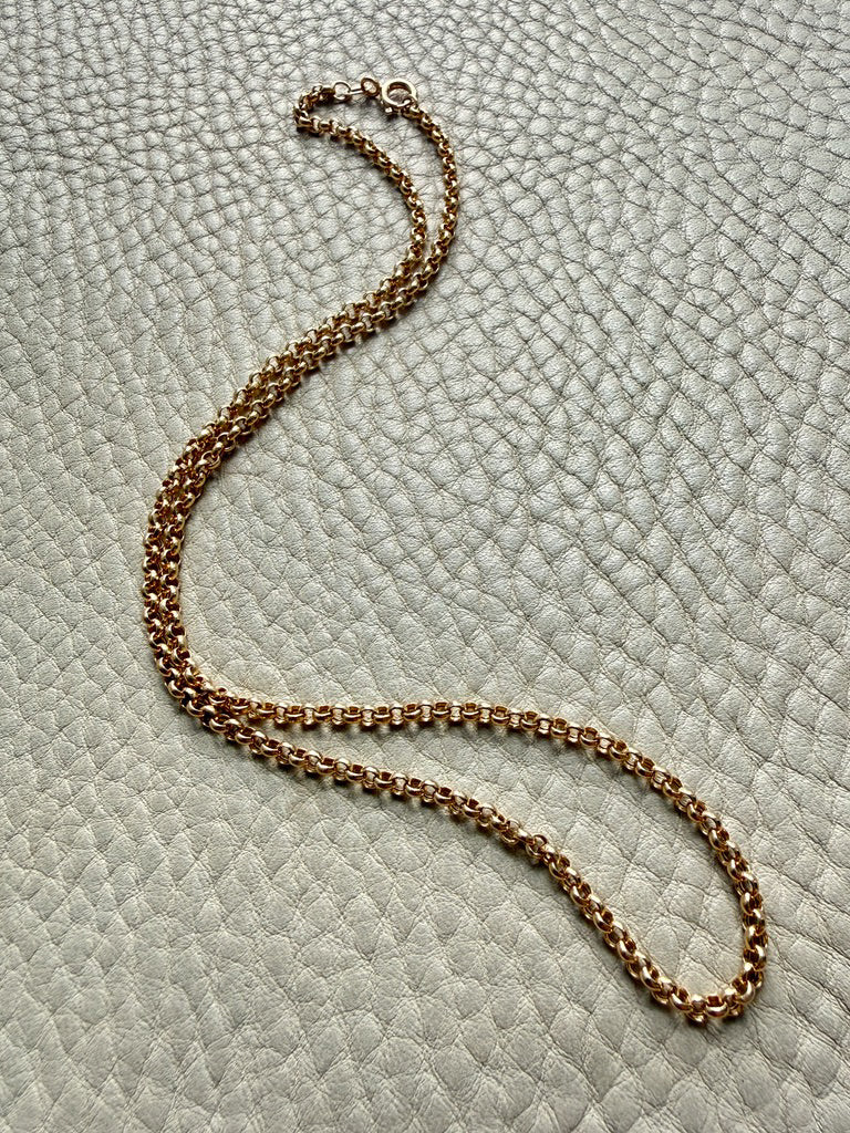 18k gold vintage rolo chain necklace on a textured light gray surface