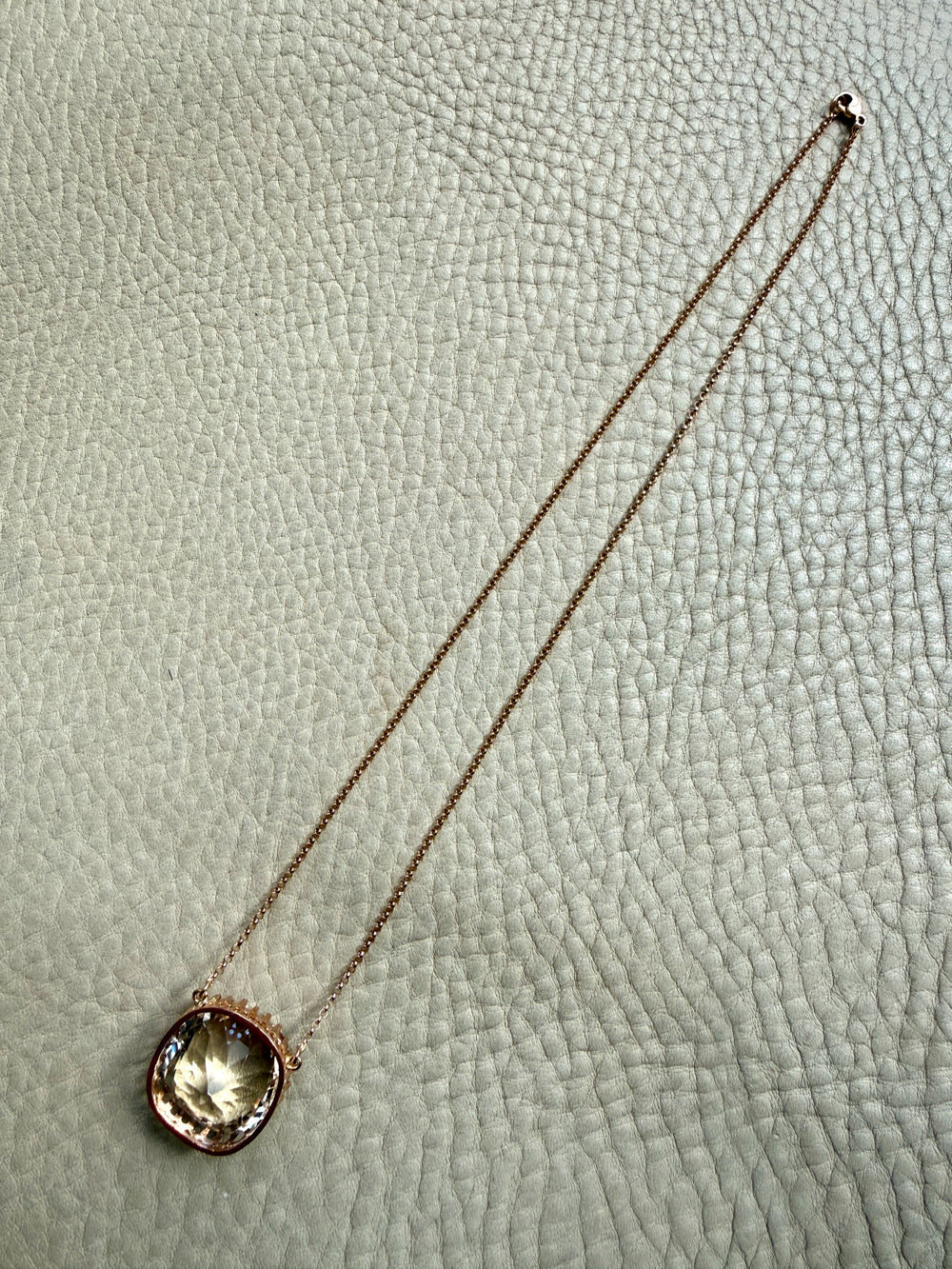 Necklace with a round pendant on a light gray textured background