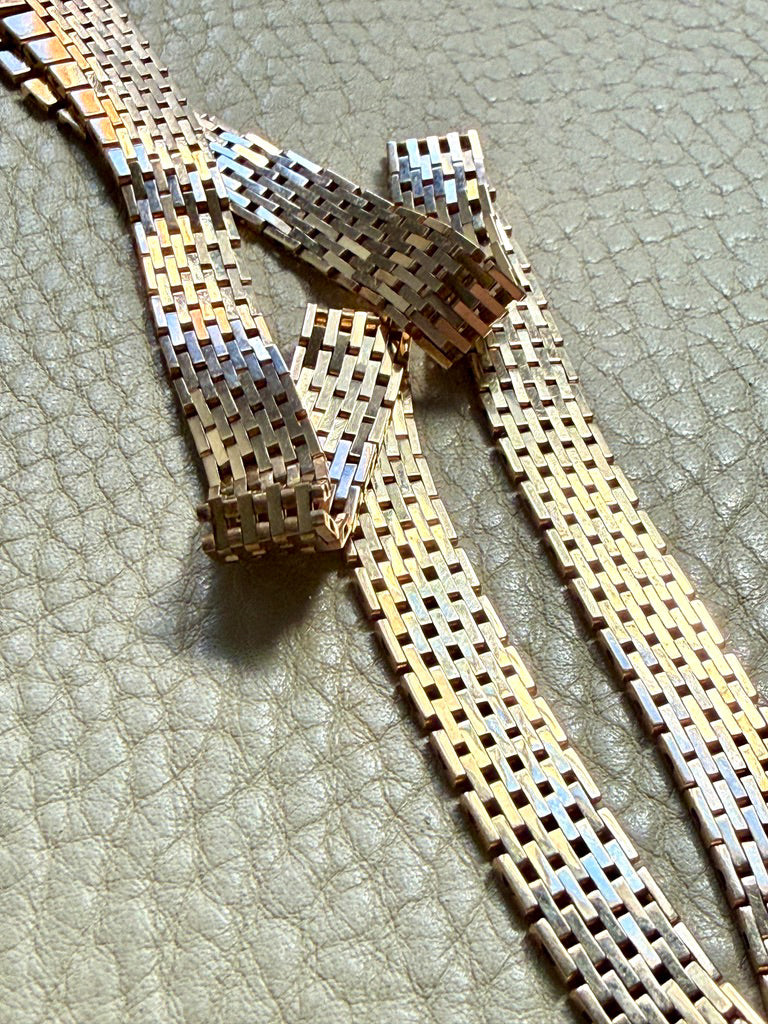 14k gold vintage cleopatra necklace on a textured surface