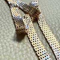 14k gold vintage cleopatra necklace on a textured surface