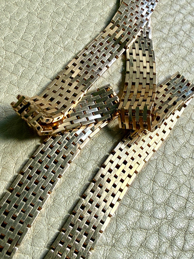 14k gold vintage cleopatra necklace on a textured surface