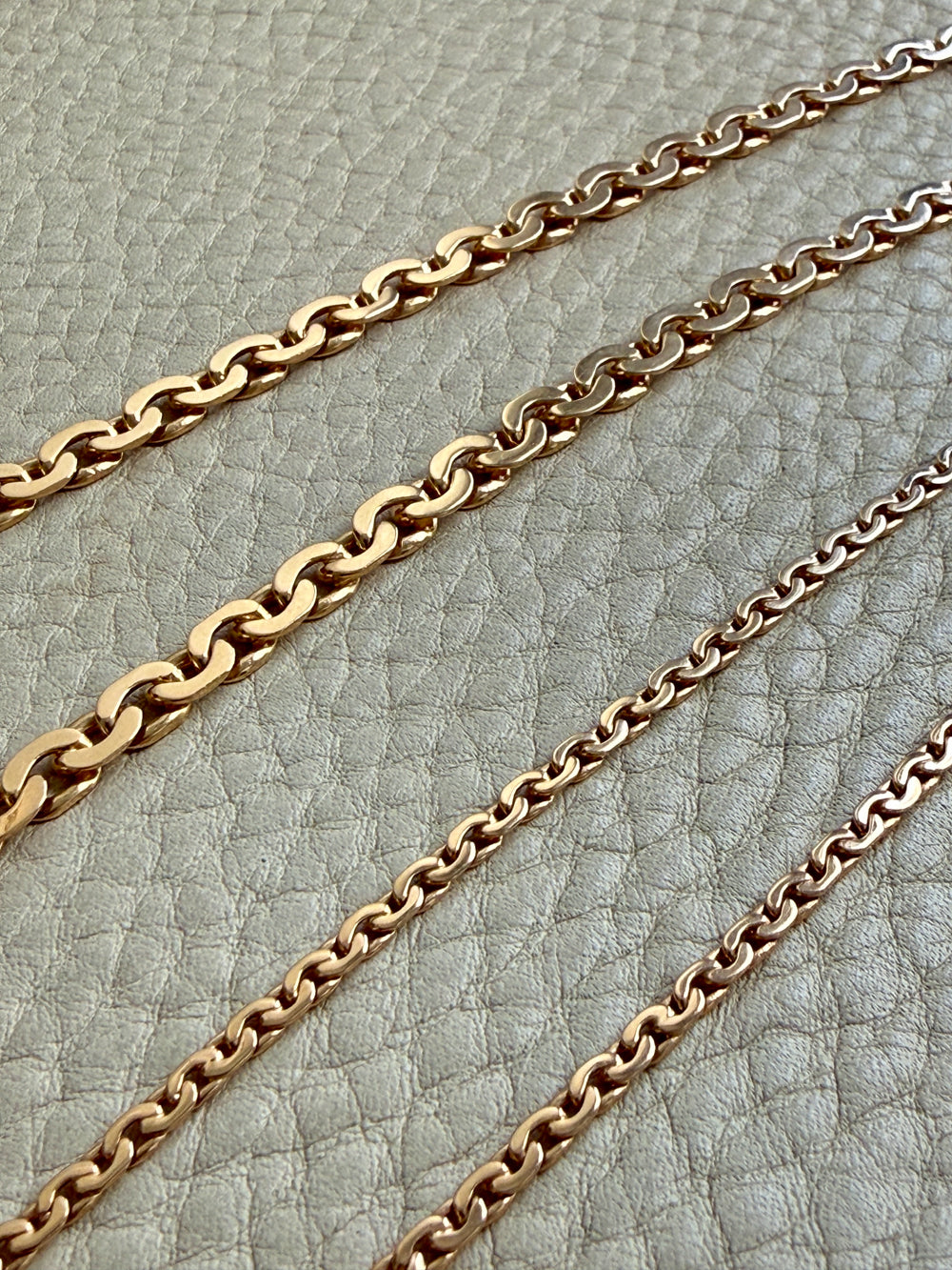 gold chain necklace on a textured gray surface