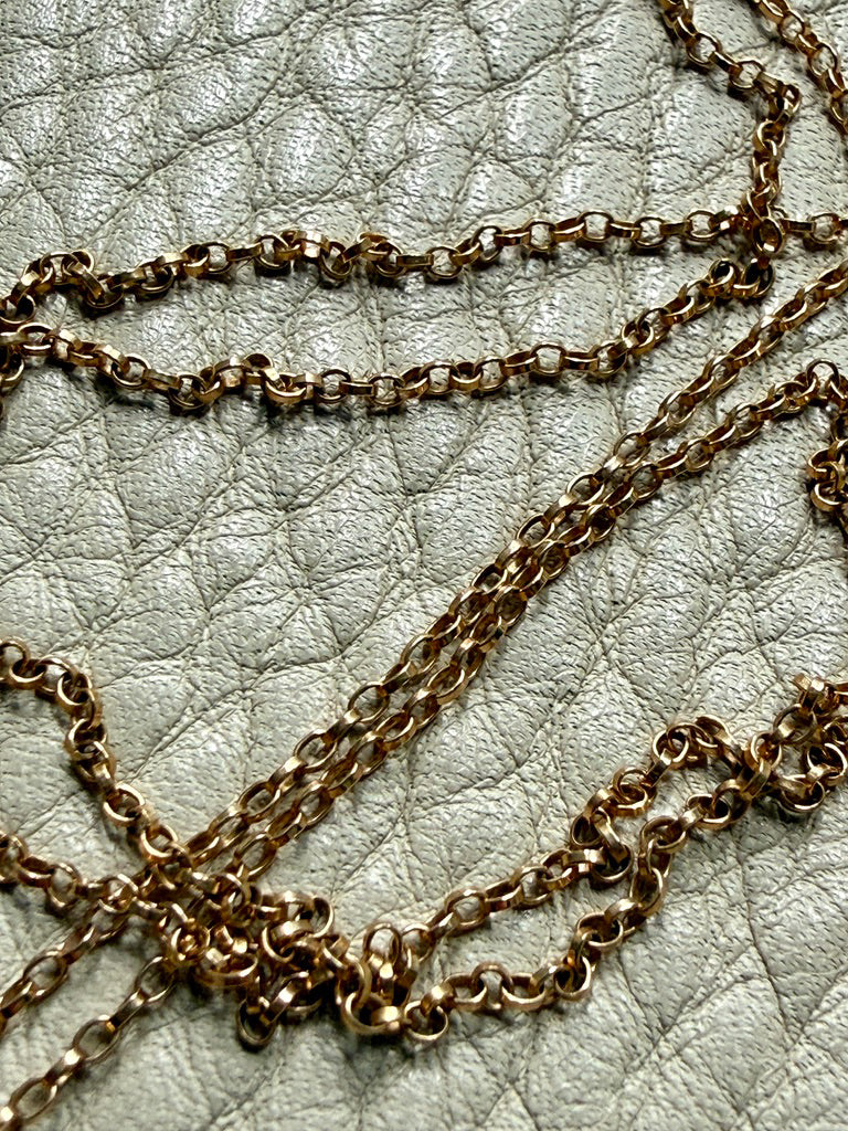 vintage 18k gold chain necklace on a textured light gray surface
